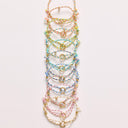 Set of colorful bracelets on a light pink background